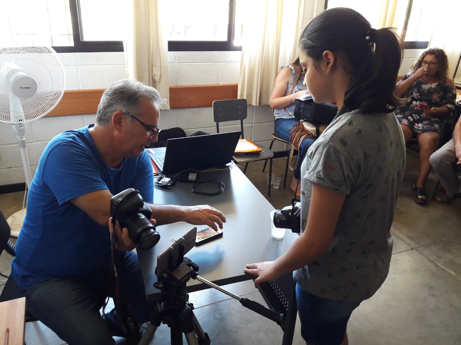 joven muchacha habla con el profesor del taller