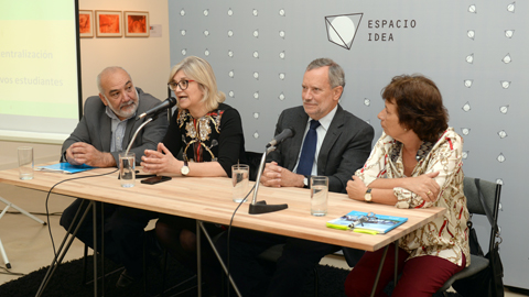 cuatro expositores sentados con microfono hablando