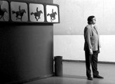 hombre parado frente a fotos